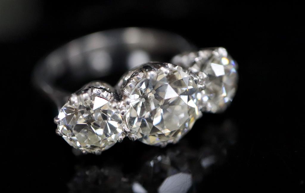 An impressive platinum and three stone diamond ring,